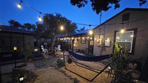 A backyard with a hammock, outdoor seating, and string lights. - 2/1 Cozy Home in the Heart of the City (Stockton)