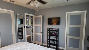 A bedroom with a bed, a ceiling fan, a TV, and a wardrobe. - 2/1 Cozy Home in the Heart of the City (Stockton)