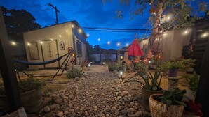 A courtyard with a gravel path, potted plants, and a hammock. - 2/1 Cozy Home in the Heart of the City (Stockton)