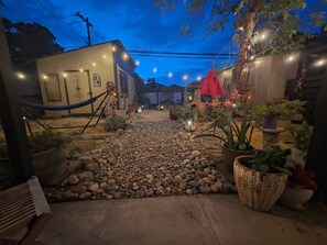 A courtyard with a gravel path, potted plants, and a hammock. - 2/1 Cozy Home in the Heart of the City (Stockton)