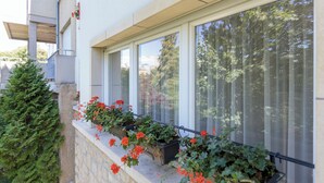 A balcony with potted plants and a stone wall. - Villa Vinicia 1 Deluxe Apartment (Luxembourg)