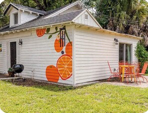 A small house with a white exterior and a mural of orange slices. - “The Clementine” Boho Home in Orlando’s Food Scene (Orlando)
