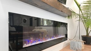 A modern living room with a large aquarium, a sofa, a coffee table, and a potted plant. - Renovated Hidden-Gem Minutes from Downtown Denver with coffee bar (Aurora)