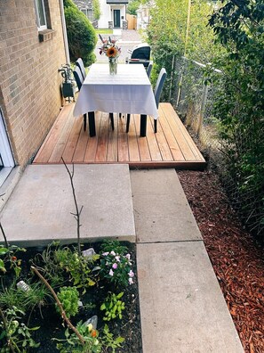 Enjoy dining al fresco on the patio, surrounded by lush gardens and a seating area.