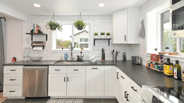 A modern kitchen with white cabinets, a stainless steel dishwasher, and a large window providing natural light. - Renovated Hidden-Gem Minutes from Downtown Denver with coffee bar (Aurora)