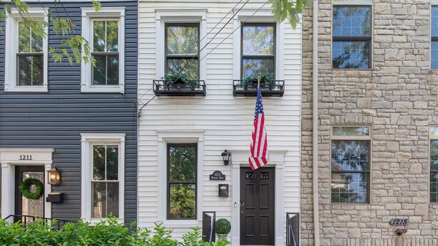 Række af byhuse med veranda, trin og et amerikansk flag.