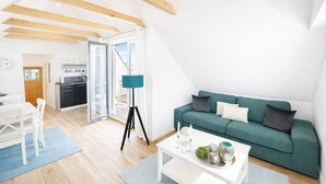 A modern apartment with a dining area, kitchen, and living room.
