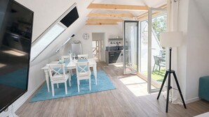 A modern interior with a dining area, kitchen, and a balcony.