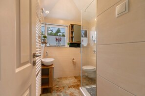 A modern bathroom with a large window, a sink, a toilet, and a shower area. - Apartment in Rosenberg – Rooftop Terrace with Rhine View near Koblenz (Lahnstein)