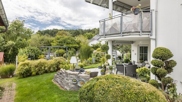 A modern house with a balcony, a well-maintained garden, and a stone wall. - Deluxe Apartment 'Griesbaum' with Private Terrace, Shared Garden and Wi-Fi (Tengen-Büßlingen)