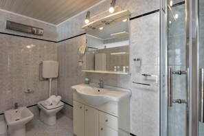 A modern bathroom with a sink, bidet, and glass shower enclosure. - Seafront Adriatic Pearl Suite, Kraljevica, Croatia (Kraljevica)