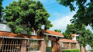 A hotel with a brick facade, large windows, and a sign reading "Mai Mountain Resort". - Mai Mountain Homestay (Nam Hoa Lu)