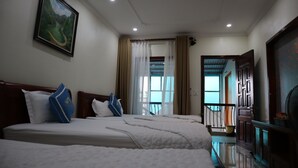A hotel room with two beds, a painting on the wall, a view through the window, and a door leading to a balcony. - Mai Mountain Homestay (Nam Hoa Lu)