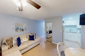 Relax and dine in this stylish living space with a sofa, dining table, and kitchen area.
