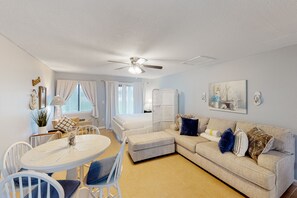 Relax in this inviting living space with a round dining table, comfortable seating area, and large window.