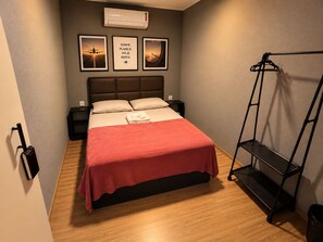 A hotel room with a bed, a wall-mounted air conditioner, and framed pictures. - On Park Hotel Translado e Café da manhã (Guarulhos)