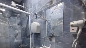 Une salle de bain avec des toilettes, un lavabo et une douche.