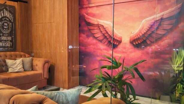 Een hotellobby met een groot muurschilderij, een bank en een potplant.