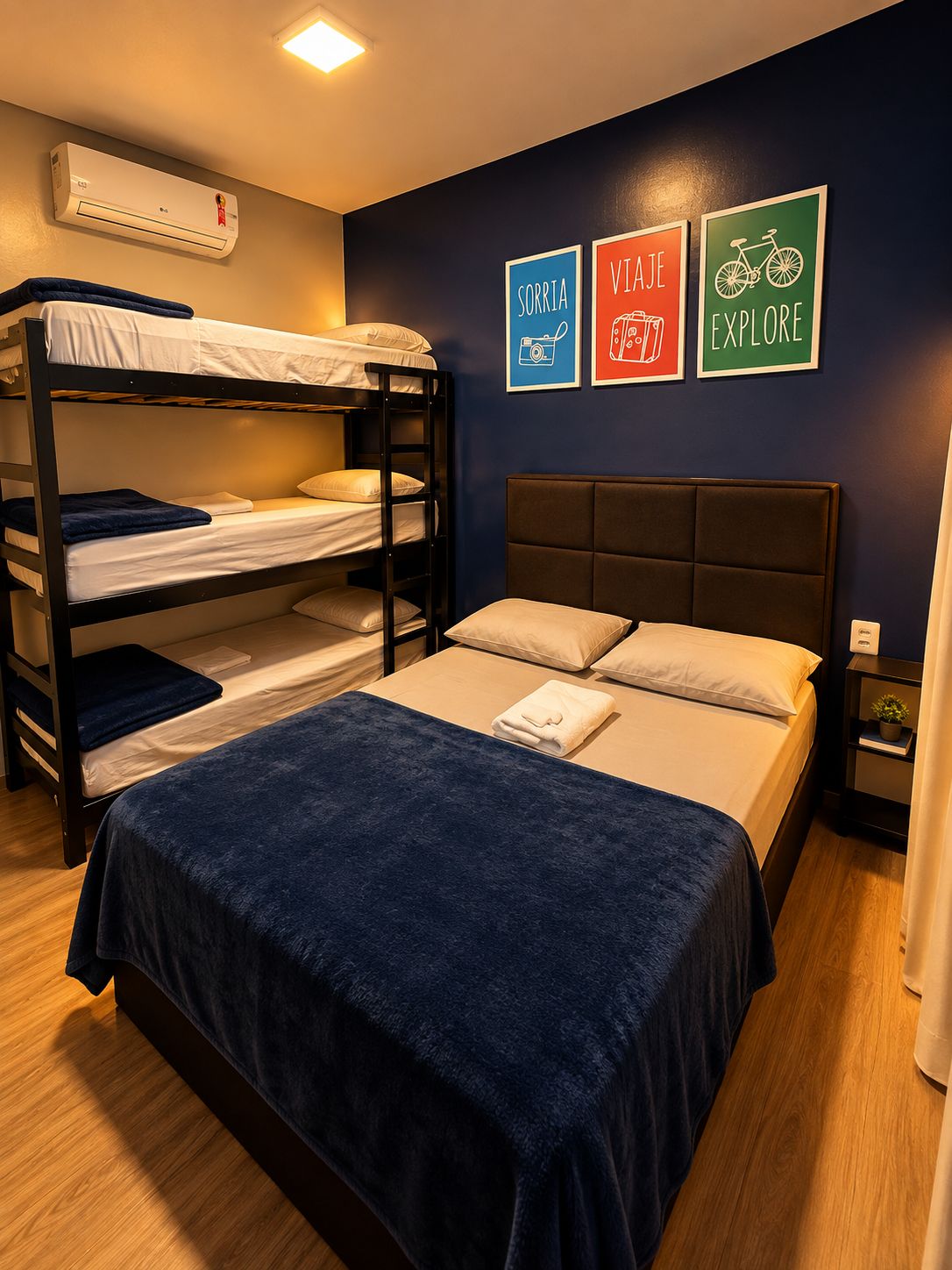 A bunk bed room with a single bed, a nightstand, and wall art.