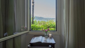 Una habitación con un amplio ventanal que ofrece vistas a zonas verdes y colinas.