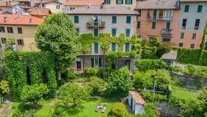 Zona residencial con varios edificios, abundante vegetación y un pequeño césped con dos sillones de descanso.