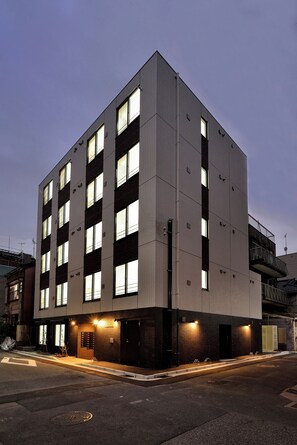 A multi-story building with a modern design, featuring a series of windows and a ground-level entrance. - Hostel Inn Tokyo Asakusa East (Tokyo)