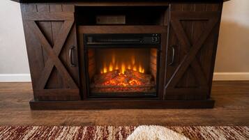 A fireplace with a modern design, featuring a built-in television above it.