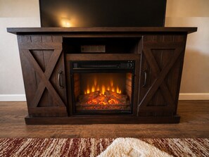 Una chimenea de diseño moderno, con un televisor integrado en la parte superior.