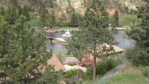 Un resort a orillas del lago con un pabellón, senderos peatonales y un pequeño puente.