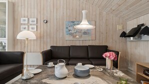 A modern living room with a wooden ceiling, a brown leather sofa, a marble coffee table with tea set, and a painting on the wall. - "Sylvia" - 900m from the sea by Interhome (Nexø)