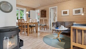 A cozy living room with a fireplace, wooden furniture, and a dining area. - "Nahuel" - 200m from the sea by Interhome (Nexø)