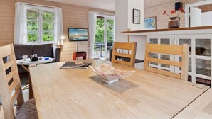 A wooden interior with a dining table, chairs, a sofa, and a television. - "Nahuel" - 200m from the sea by Interhome (Nexø)