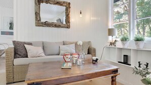 A cozy living room with a wooden coffee table, a white sofa, and a large mirror on the wall. - "Selvi" - 125m from the sea by Interhome (Nexø)