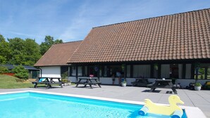 A swimming pool with a yellow duck float, picnic tables, and a building with a tiled roof. - "Georg" - 300m from the sea by Interhome (Nexø)