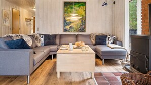 Ein gemütliches Wohnzimmer mit einer Eckcouch, einem Couchtisch und einem Kamin.