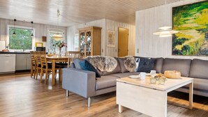Ein modernes Wohnzimmer mit Sofa, Couchtisch und Essbereich.