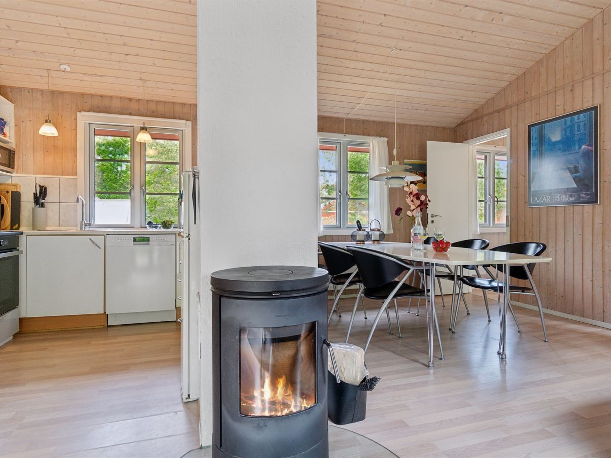 Une cuisine moderne avec des meubles en bois, un four encastré et une cuisinière à foyer apparent.