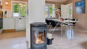Una cocina moderna con armarios de madera, un horno empotrado y una estufa con llama visible.