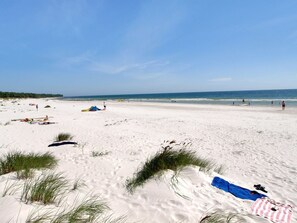 A beach with white sand, sparse vegetation, and a clear blue sky. - "Elsamaria" - 400m from the sea by Interhome (Nexø)