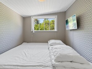A bedroom with a single bed, a window, and a wall-mounted TV. - "Kerstin" - 100m from the sea by Interhome (Nexø)