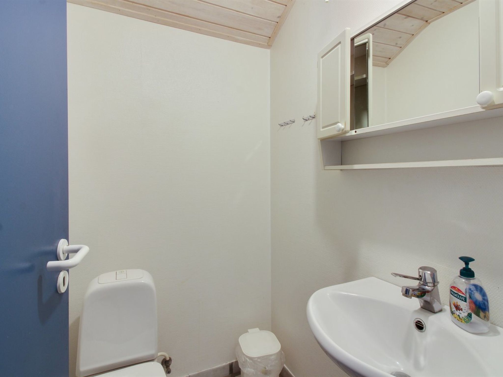 Ein Badezimmer mit Toilette, Waschbecken und Spiegel.