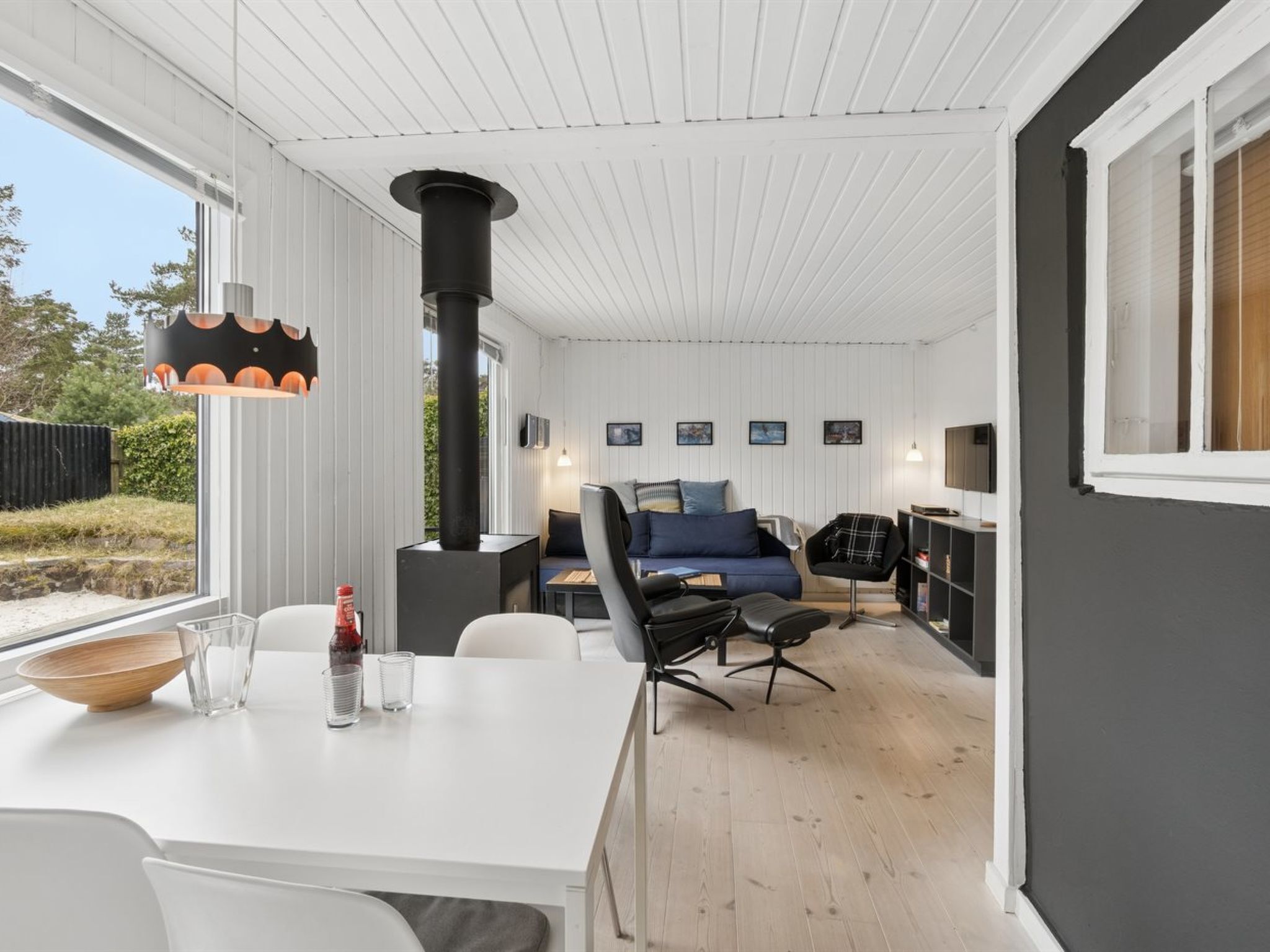 A modern interior with a dining area, a sofa set, and a fireplace.