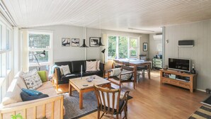 A spacious living area with a wooden floor, a sofa, a dining table with chairs, a television, and artwork on the walls. - "Kjeld" - 900m from the sea by Interhome (Nexø)