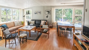 A spacious living room with a wooden ceiling, a sofa, a dining table, and a TV. - "Kjeld" - 900m from the sea by Interhome (Nexø)
