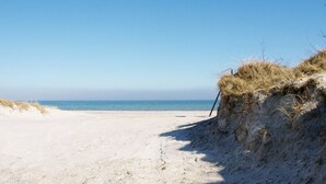 A sandy beach with dunes and a clear blue sky. - "Bergulv" - 75m from the sea by Interhome (Nexø)