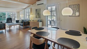 A modern, well-lit room with a wooden ceiling, large windows, a dining table with chairs, and a sofa. - "Zeytun" - 800m from the sea by Interhome (Nexø)