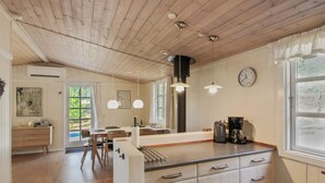 A modern kitchen with wooden ceiling, pendant lights, a coffee station, and a view of the outdoors. - "Zeytun" - 800m from the sea by Interhome (Nexø)