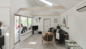 Un espacio habitable amplio con un gran ventanal, una mesa de comedor y un sofá.