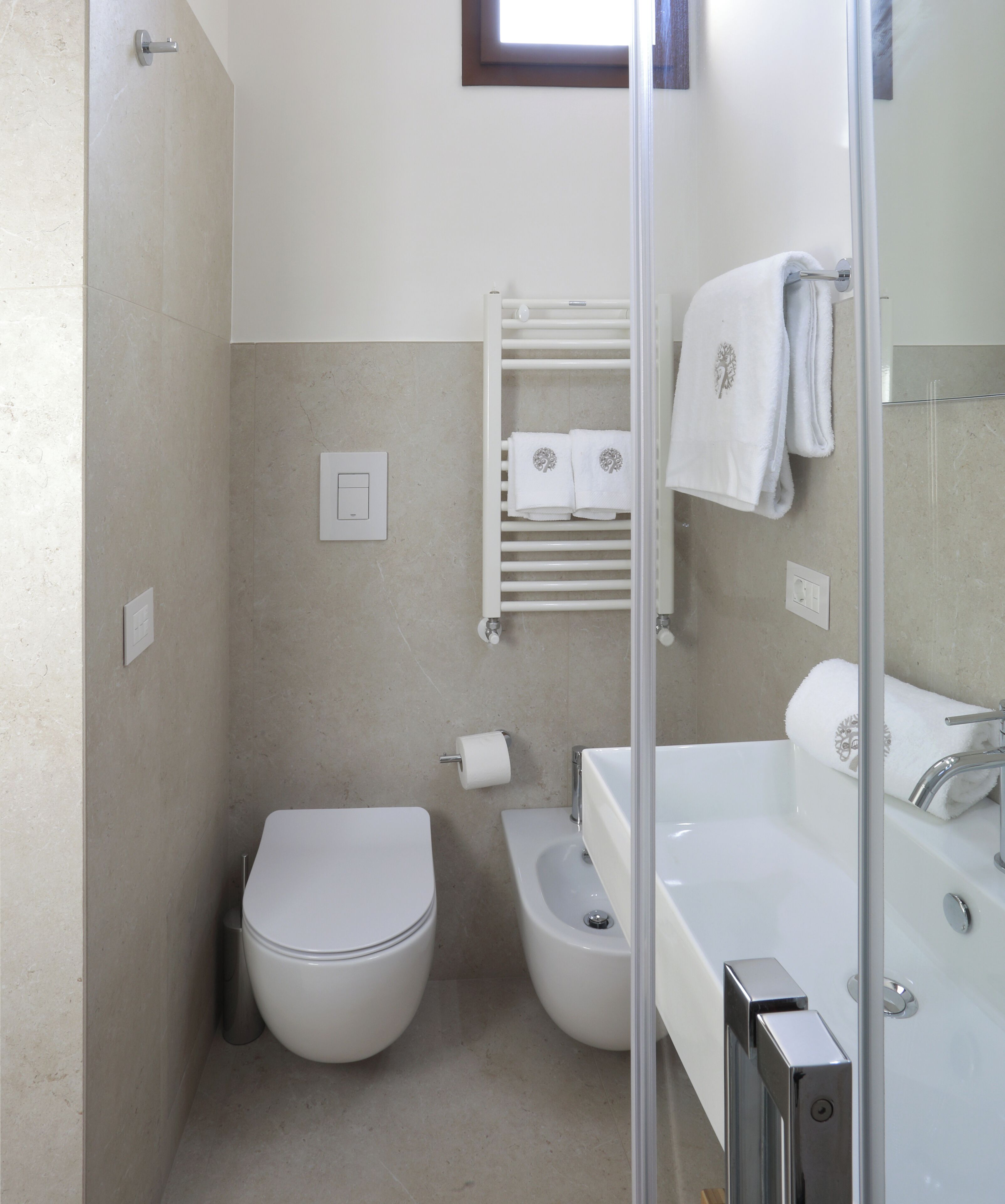 Een moderne badkamer met toilet, bidet en bad.