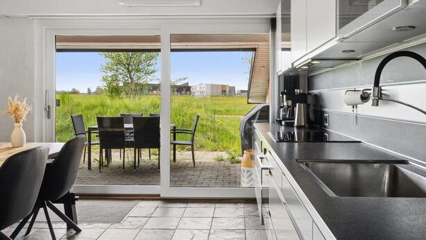 Een moderne keuken met een inbouwoven, een koffiezetapparaat en een spoelbak.
